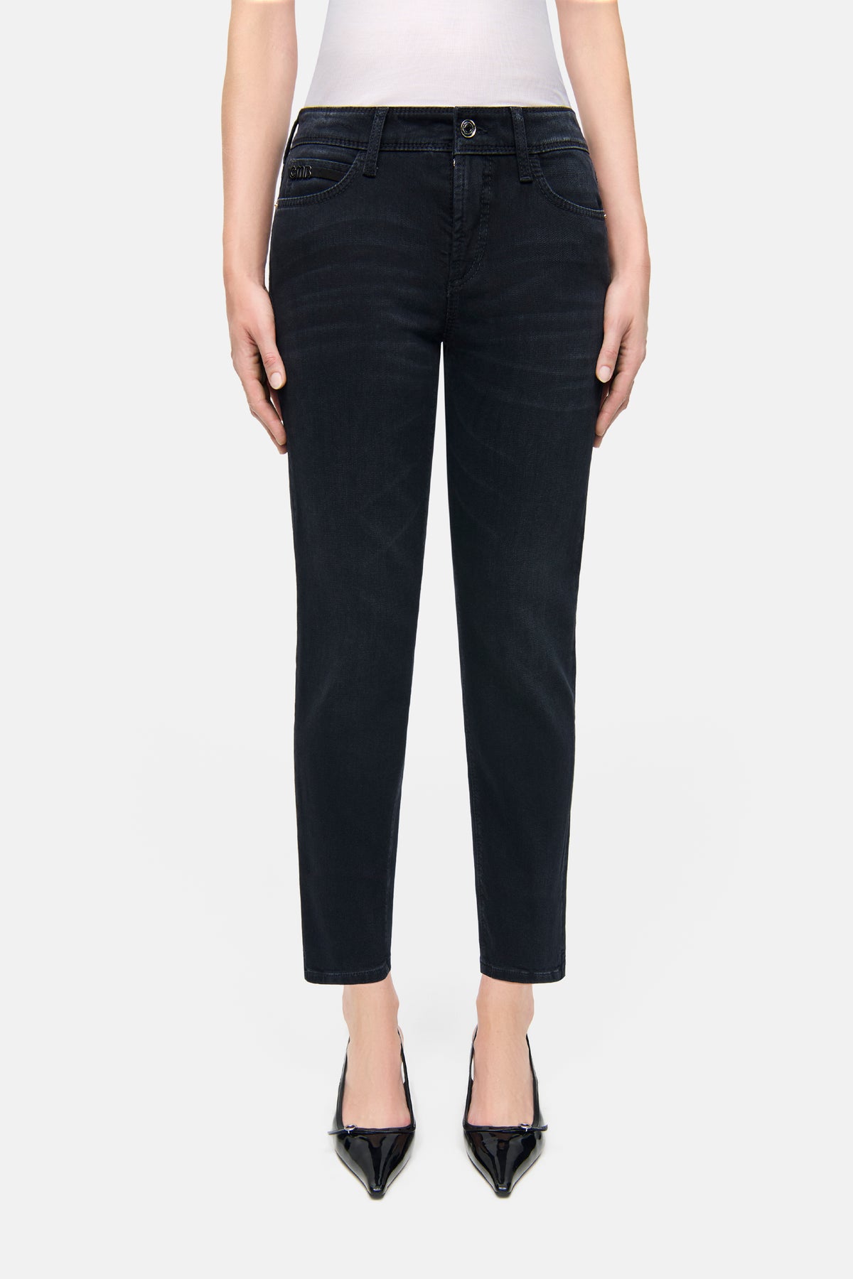 Schwarze Slim-Fit-Jeans aus 57% Baumwolle, 37% Modal, 4% Elastomultiester T400, 2% Elasthan, getragen in urbanem Umfeld.