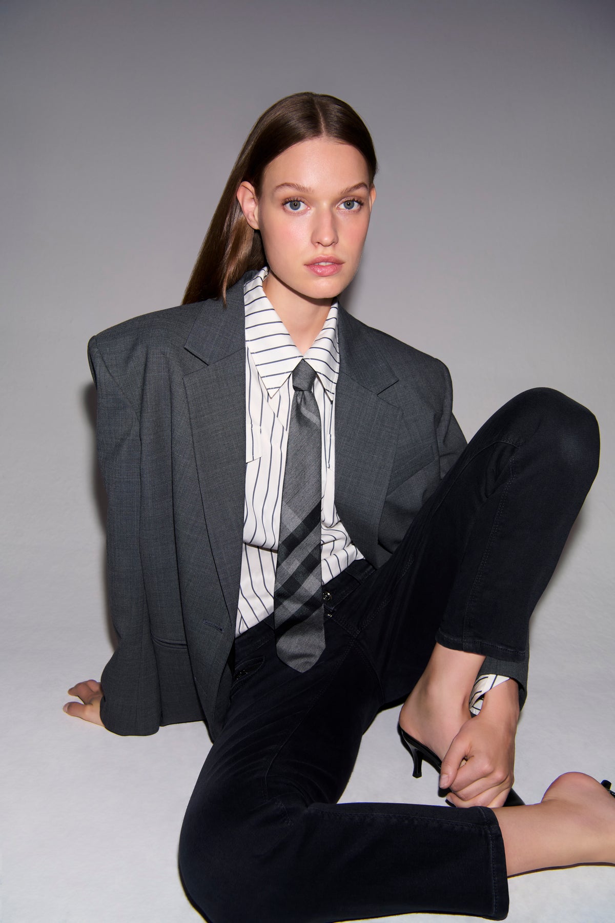 Schwarze Slim-Fit-Denimhose aus 57% Baumwolle, 37% Modal, 4% Elastomultiester T400, 2% Elasthan. Getragen in einer formellen Umgebung.